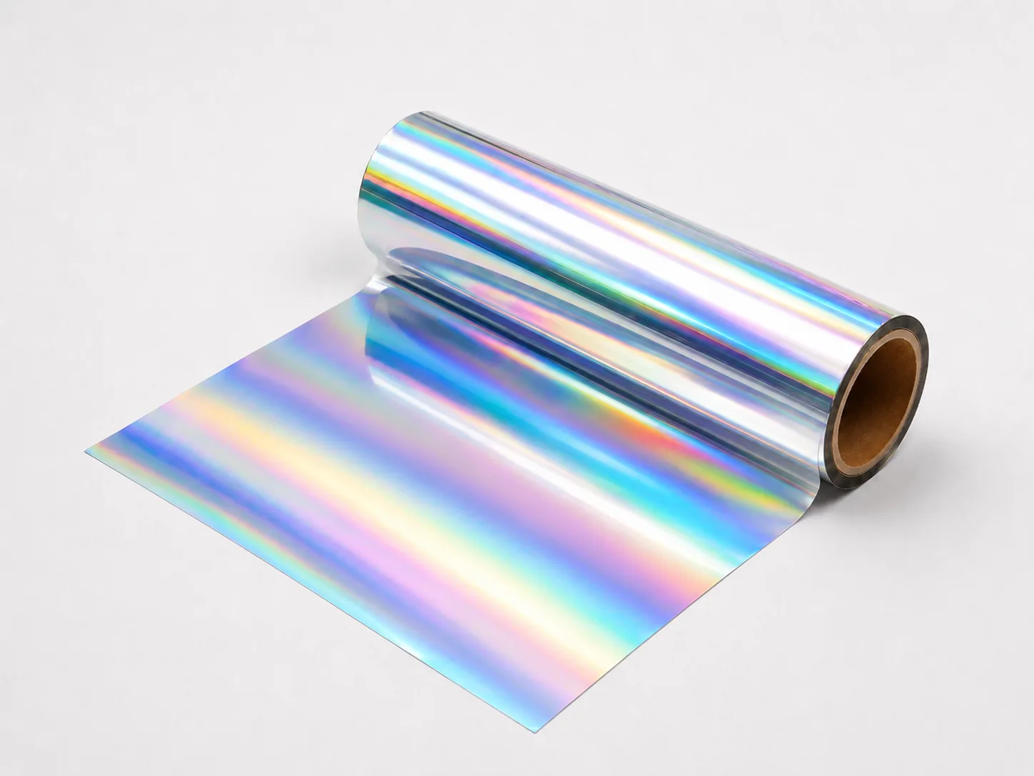 Holographic cold foil web unwinding from master roll showing uniform rainbow diffraction coverage edge to edge