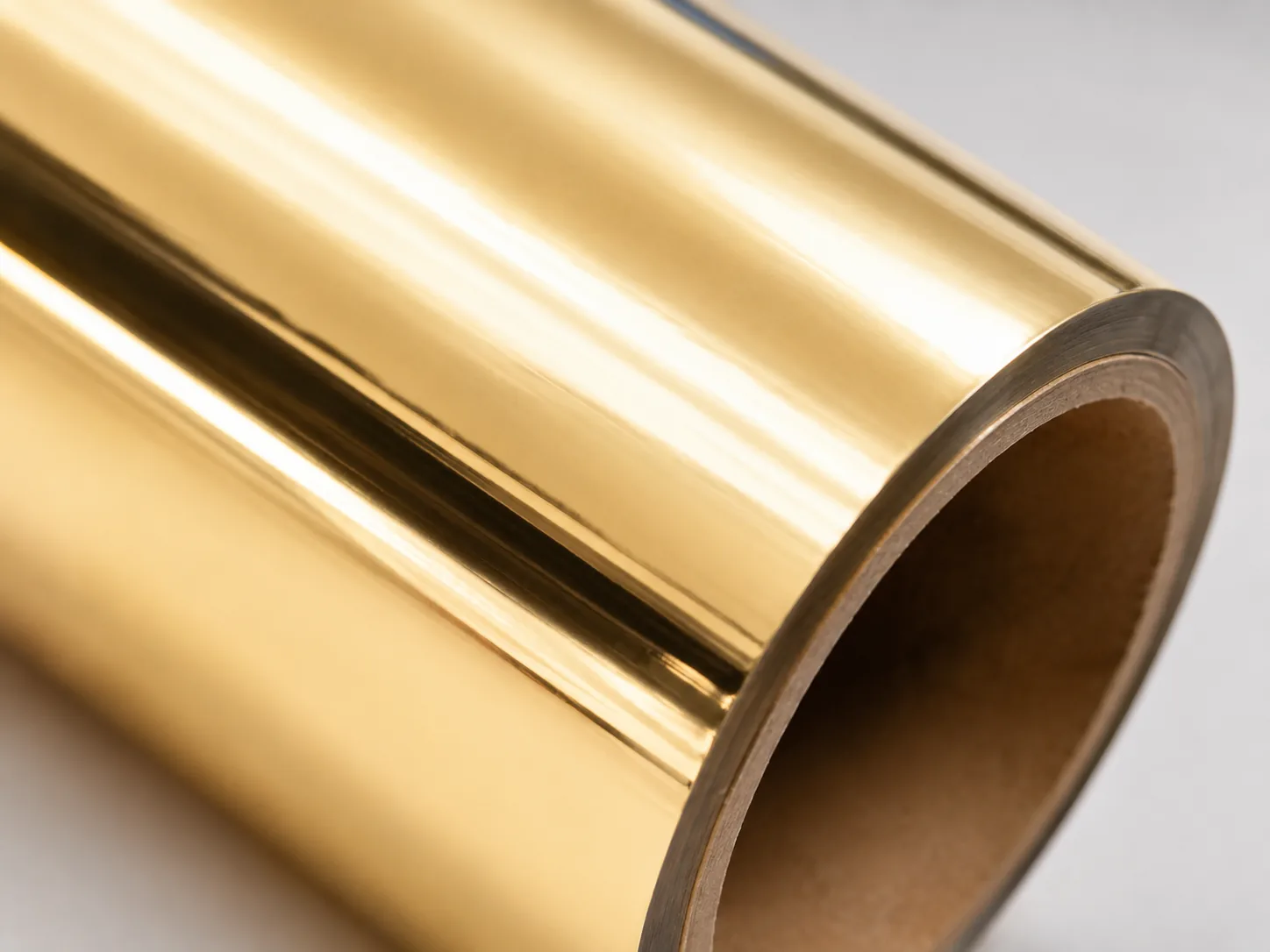 Macro detail of Pale Gold cold foil surface showing 88 GU satin-mirror finish and warm 18K champagne tonality