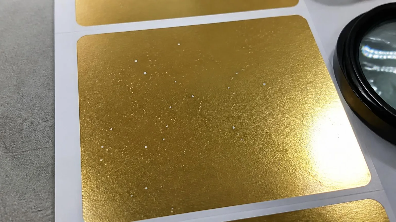 Cold foil pinhole defect example on metallic label print
