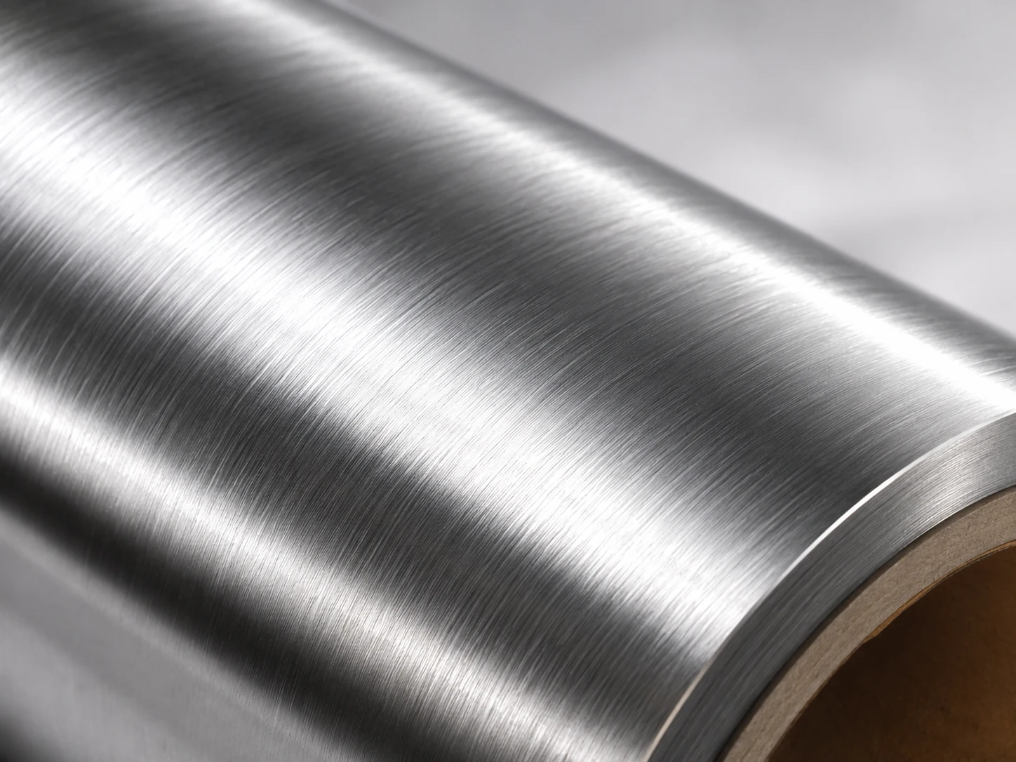 Macro detail of brushed cold foil showing directional hairline grain and low-gloss satin finish