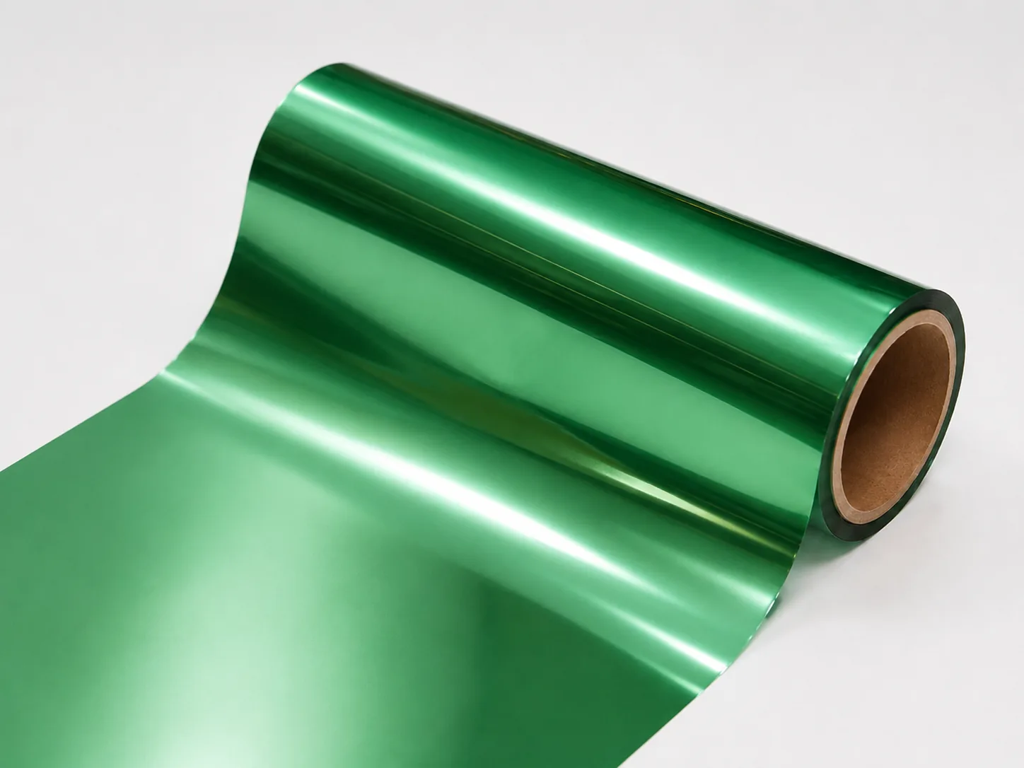 Deep Emerald cold foil web unwinding from master roll showing consistent metallic emerald coverage edge to edge