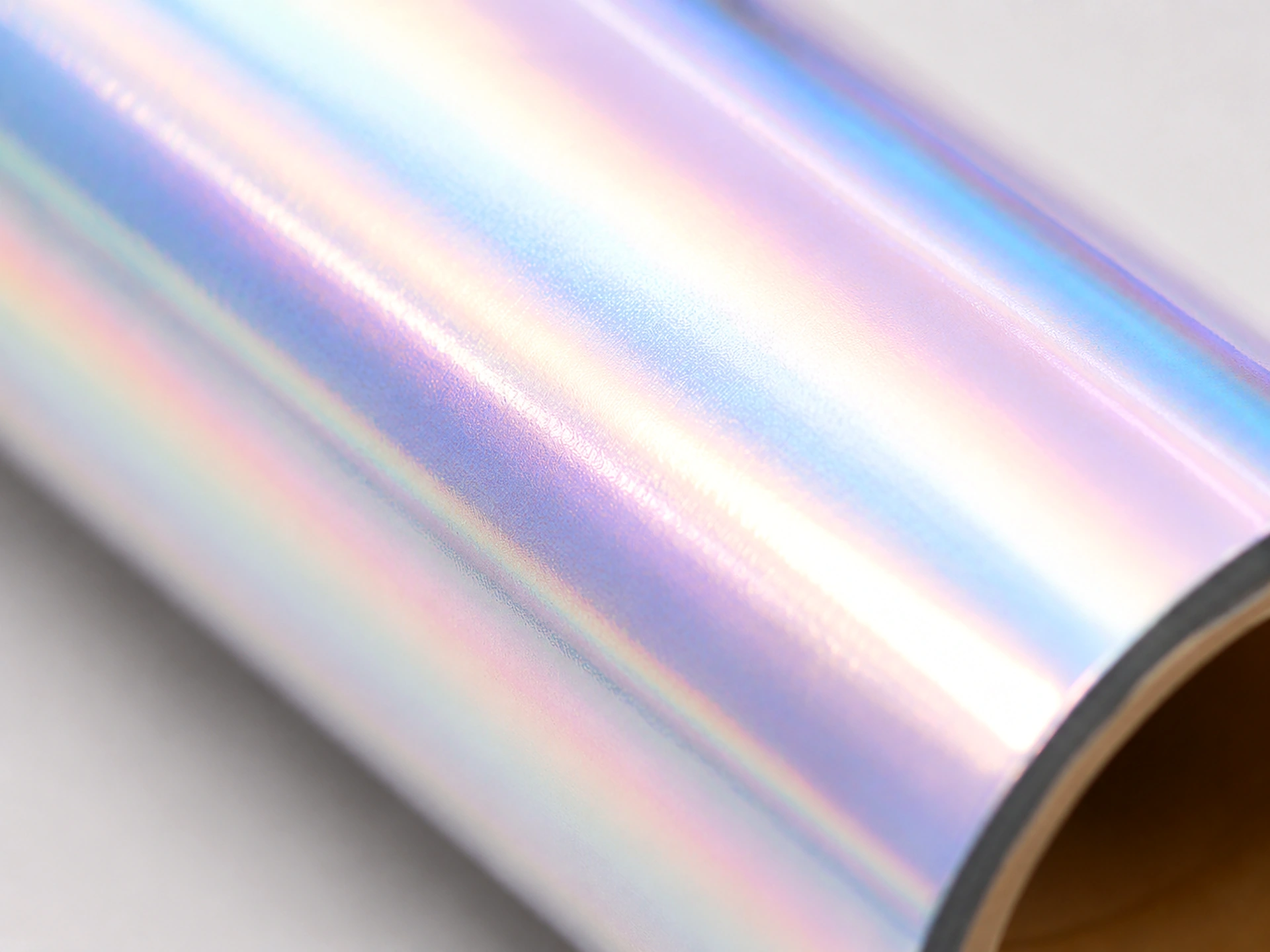 Macro detail of Iridescent Pearl cold foil surface showing gentle blue, violet and rose pastel color shift