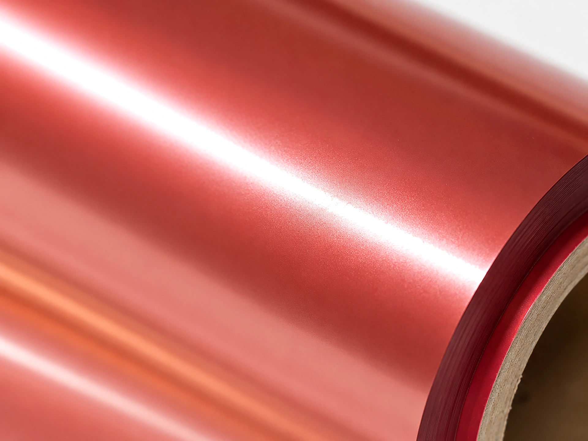 Macro detail of Rose Gold cold foil surface showing 90 GU mirror gloss with warm copper-pink chroma